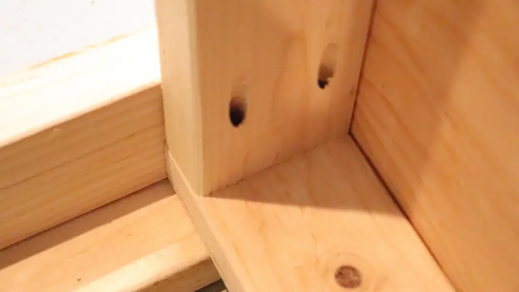 Drilled holes in the 2x4 wood used in our DIY custom garage shelf