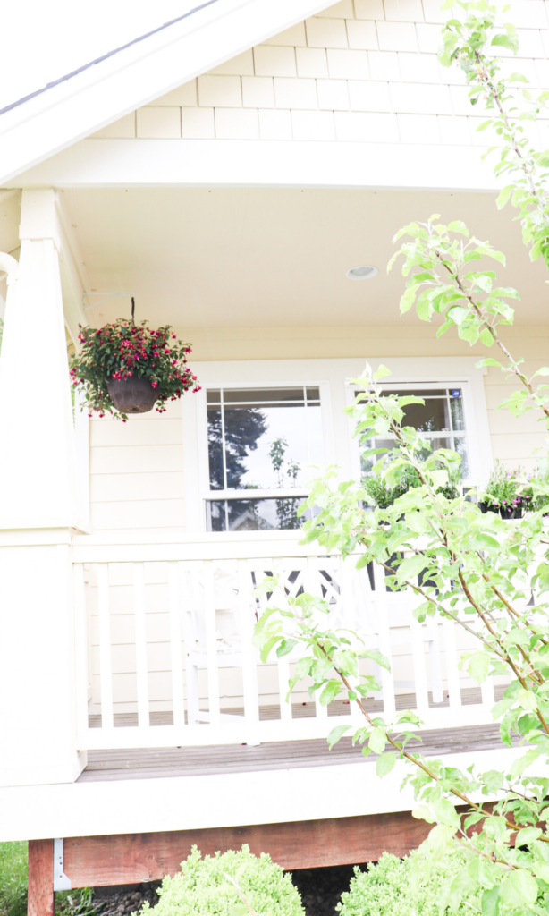 Fuchsia basket on the farmhouse porch with the view of the deck