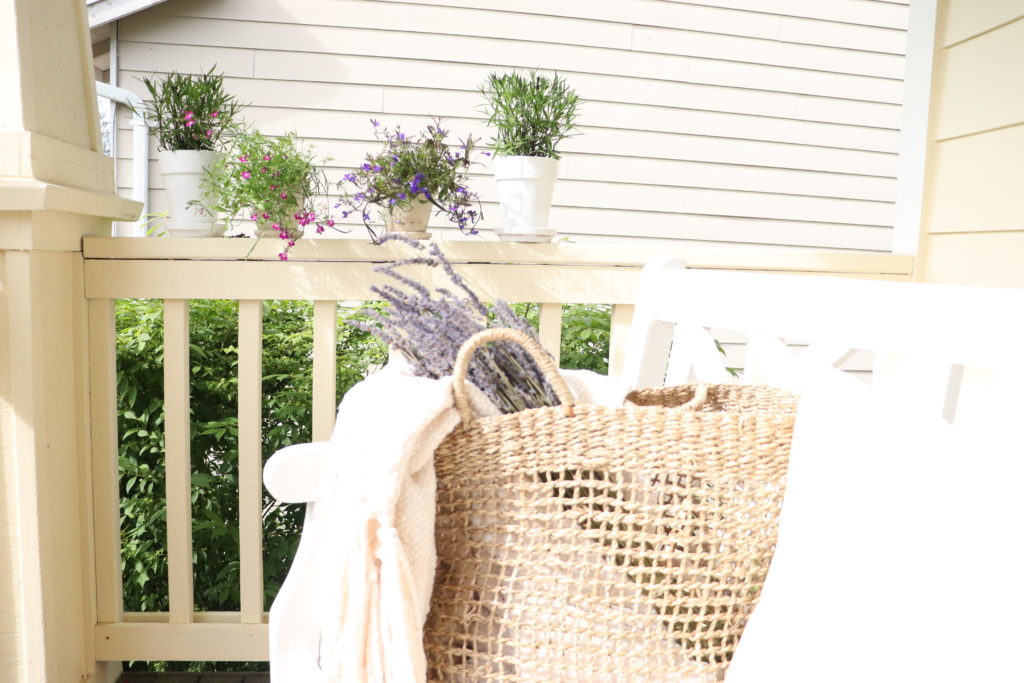 flowers and a woven basket with lavender in the farmhouse garden front porch