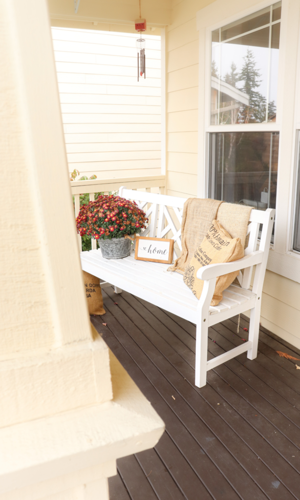 fall front porch with mums and a pillow