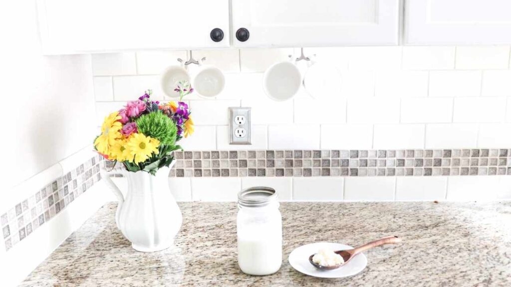 milk kefir in a mason jar next to flowers on the countertop