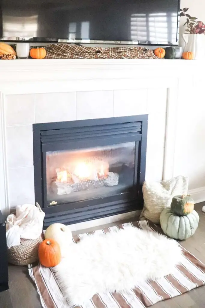 cozy fireplace scene with pumpkins and pillows 