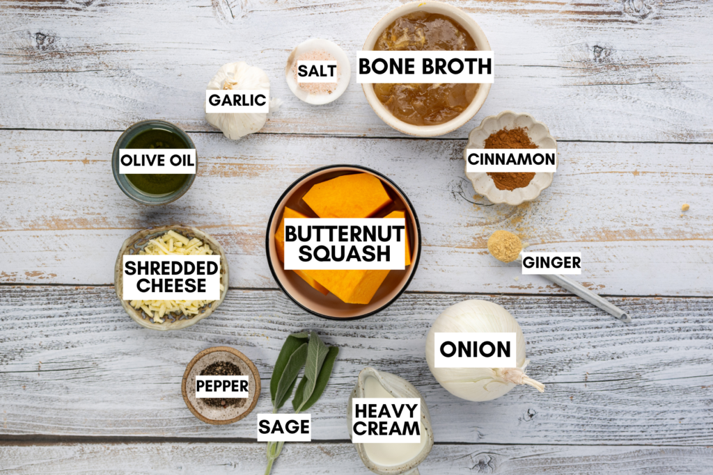 Ingredients for butternut squash soup including butternut squash, bone broth, onion, garlic, heavy cream, shredded cheese, sage, olive oil, and spices.