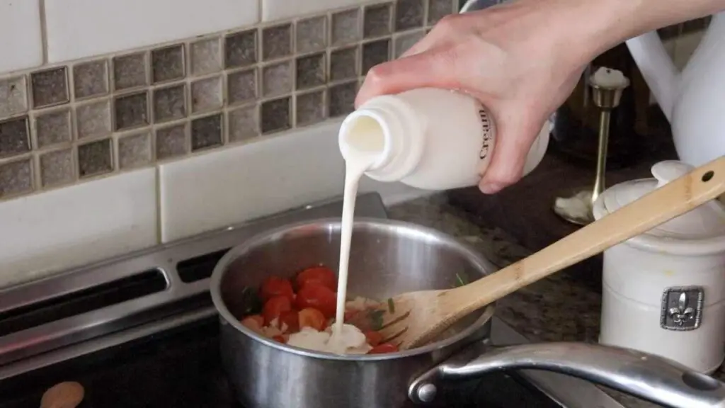 woman pouring cream into saucepan for homemade pizza sauce