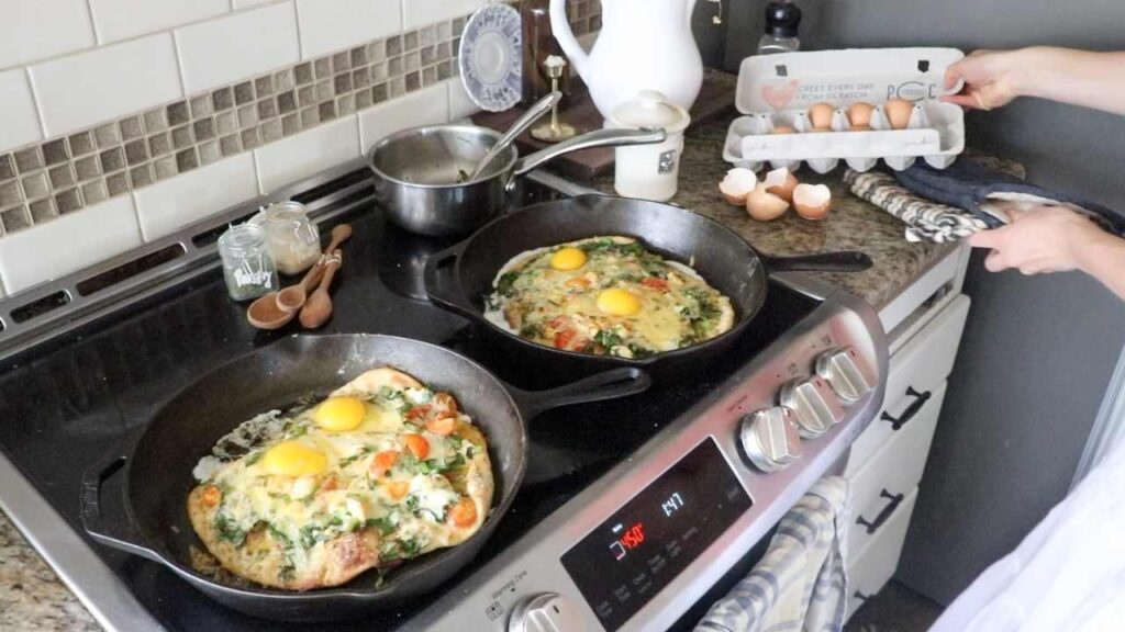 two cast iron skillets with chicken and vegetable pizza on top of sourdough pizza crust