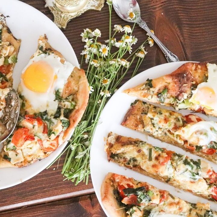 two sourdough pizzas with chicken and veggies cut into slices