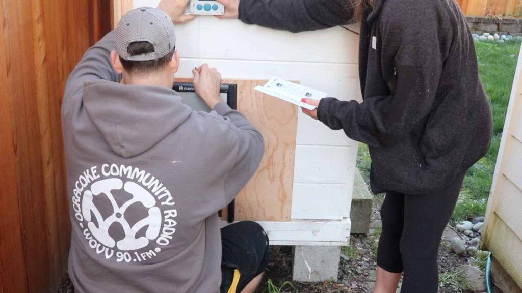 husband and wife installing an automatic chicken coop door