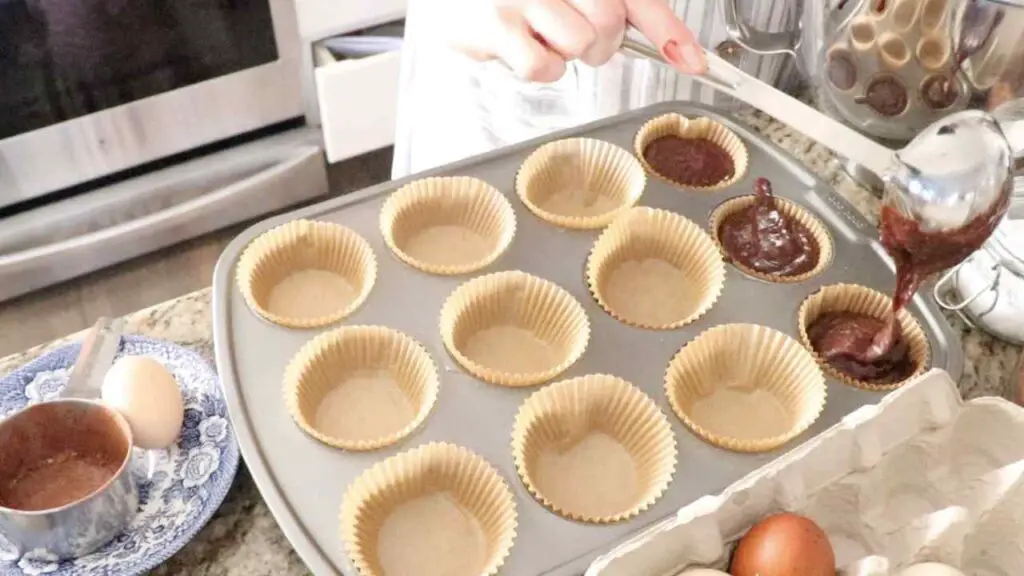 pouring cupcake batter into the cupcake molds