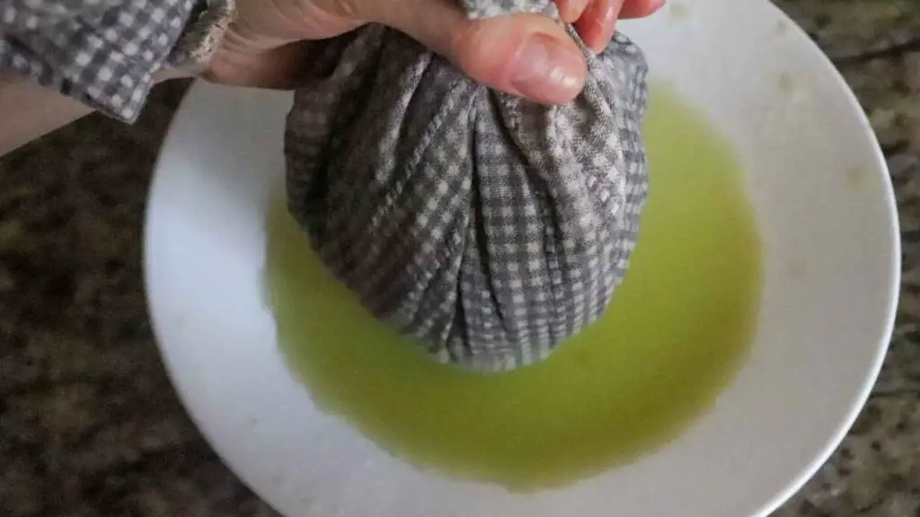 straining liquid out of grated zucchini