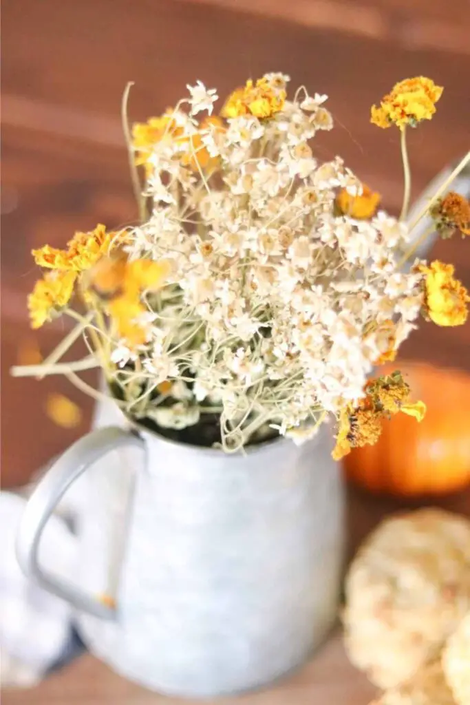 bouquet of fall flowers in a rustic pitcher