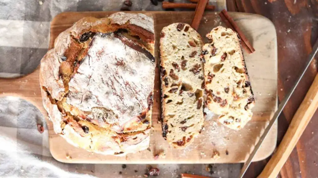 Einkorn sourdough cinnamon raisin bread on a wood board with checked cloth