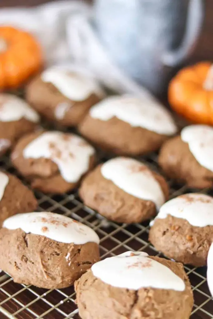 iced pumpkin cookies with sourdough discard cooling on a rack