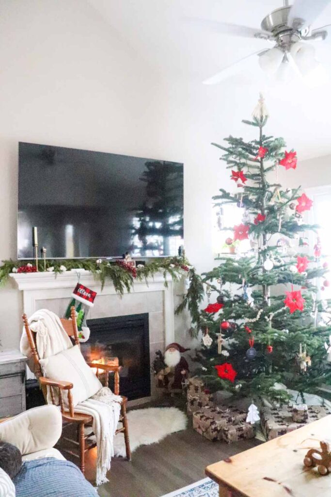 Christmas tree by the fireplace in a cozy farmhouse living room