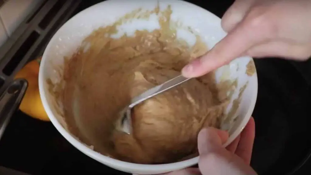 mixing batter for sourdough pumpkin pancakes in a white mixing bowl