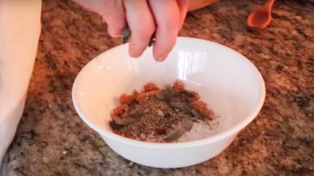 preparing a rub in a white bowl for fall apart pork shoulder roast