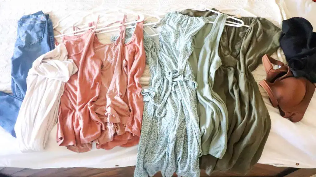 a summer maternity capsule wardrobe on a bed