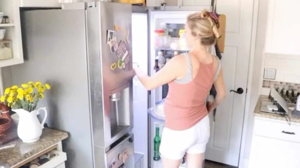 woman adding a bowl of homemade sunscreen to the fridge to chill