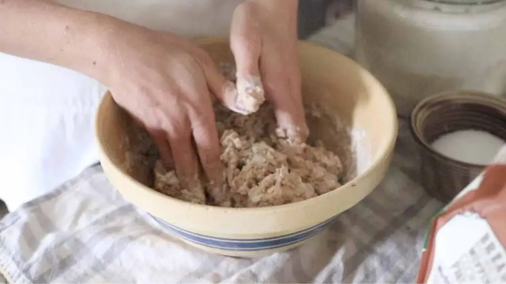 combining ingredients for seeded sourdough sandwich bread in a bowl