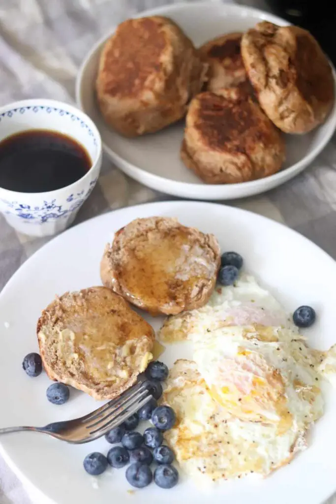 breakfast of whole wheat sourdough English muffins with honey butter, fried eggs, blueberries, and coffee