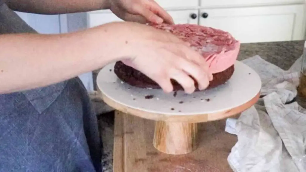 Placing raspberry ice cream layer onto chocolate cake layer for homemade ice cream cake