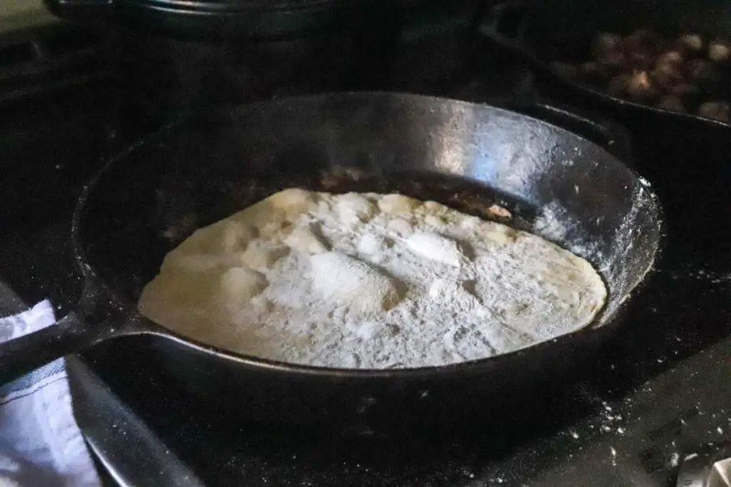 cooking einkorn sourdough discard tortillas in a cast iron skillet