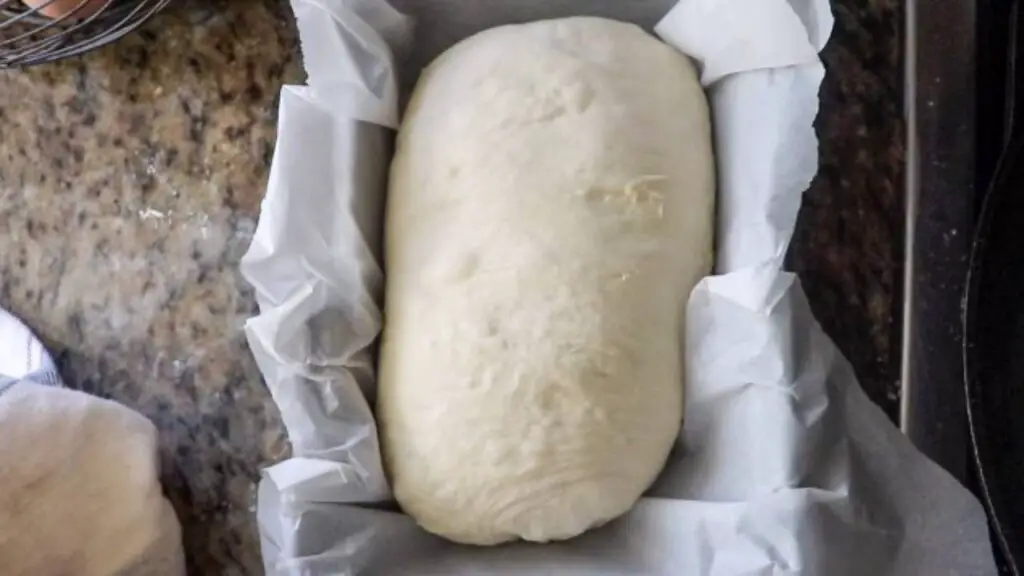 Shaped loaf in a parchment paper-lined loaf pan. 