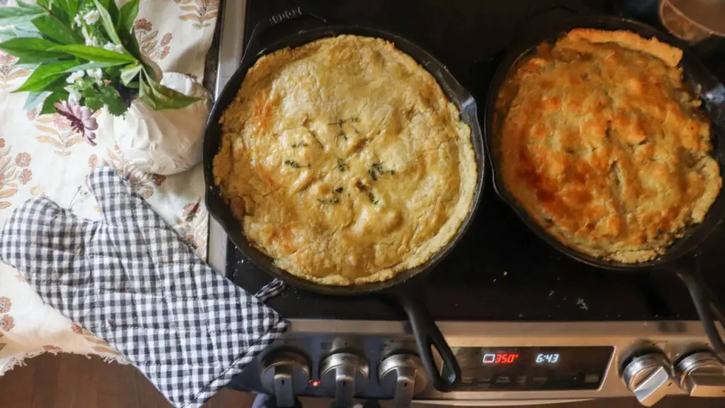 Sourdough chicken pot pie fresh out of the oven. Sitting next to it is a second pie and an oven mitt.