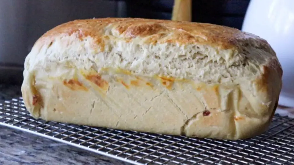 A freshly baked loaf of einkorn sourdough sandwich bread on a cooling rack. 