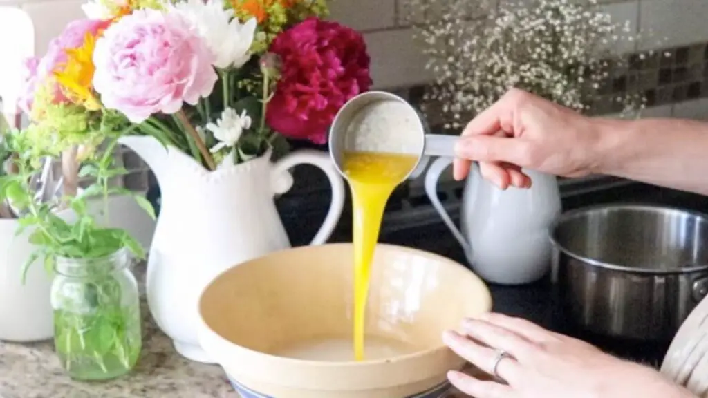 Pouring butter into a bowl to make einkorn sourdough sandwich bread dough. 