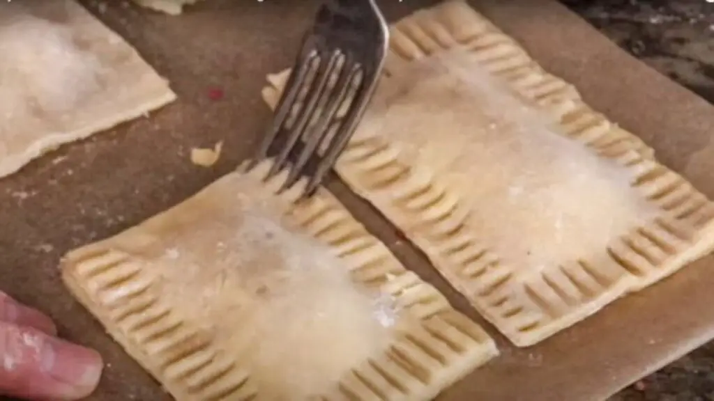 Crimping the edge of homemade pop tarts with a fork.