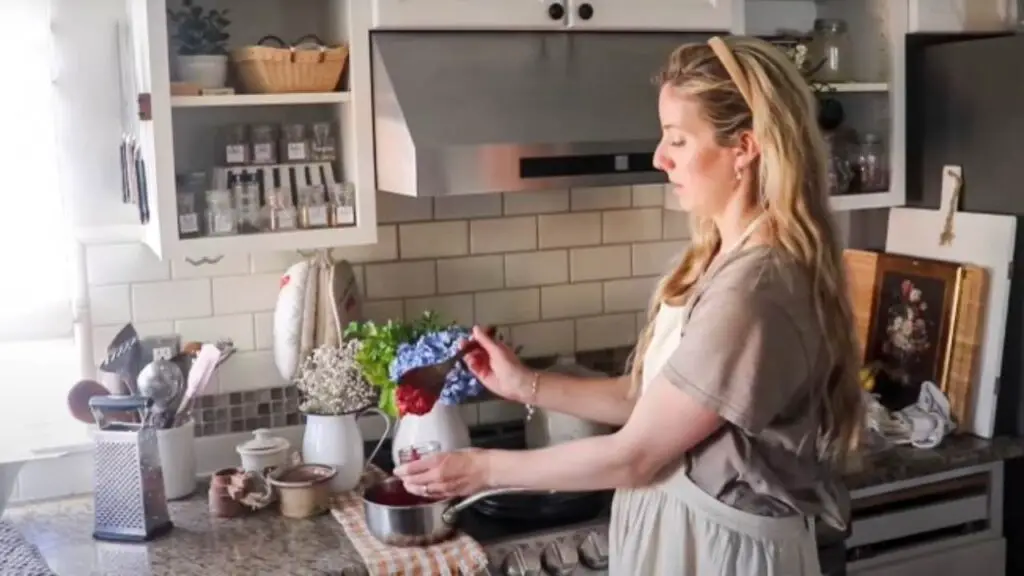 Spooning raspberry jam into jars to use in homemade pop tarts.