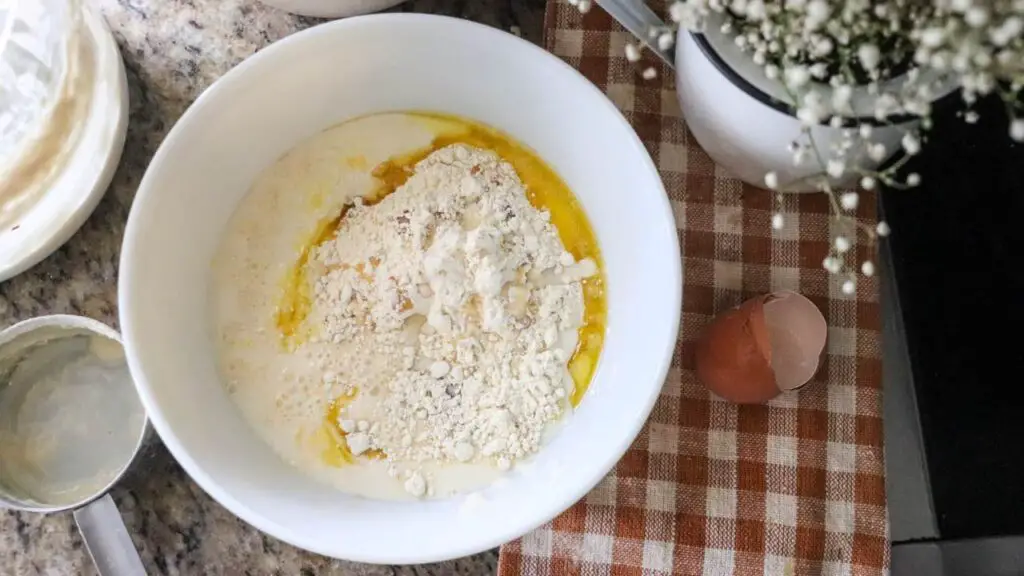 Sourdough crepe ingredients in a white bowl before mixing.