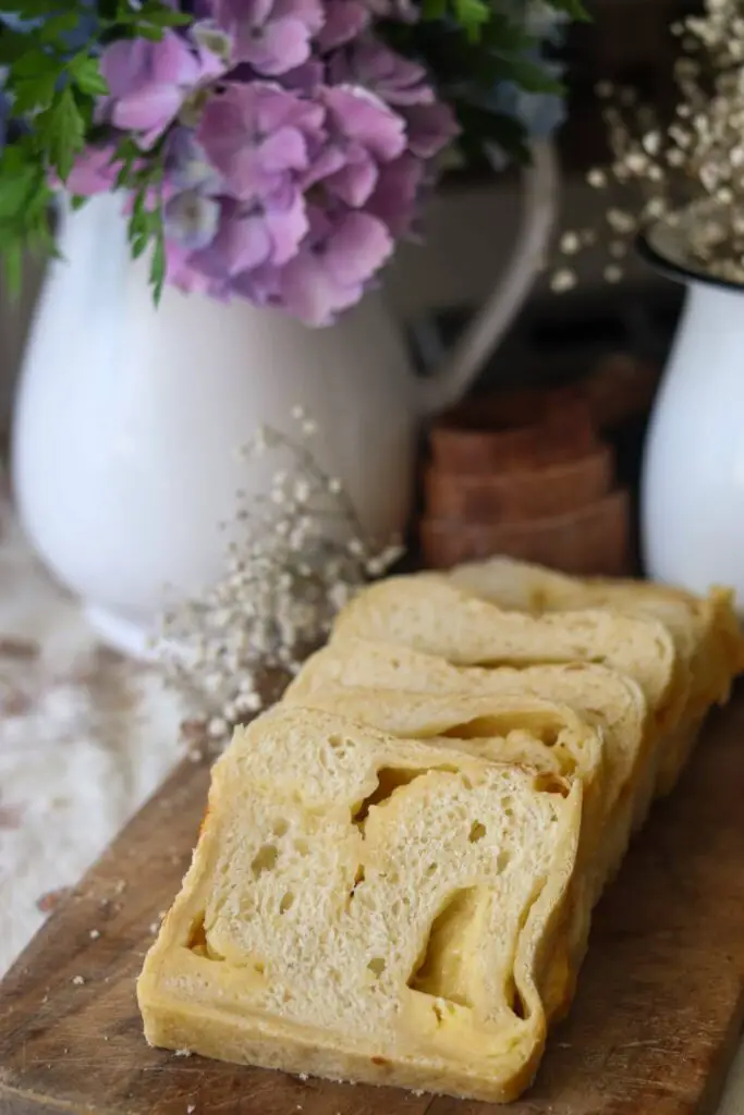 Slices of cheese bread on a wood cutting board.