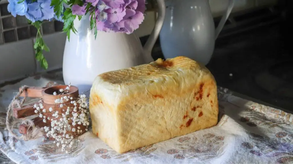 A whole loaf of cheese sourdough bread on a counter.