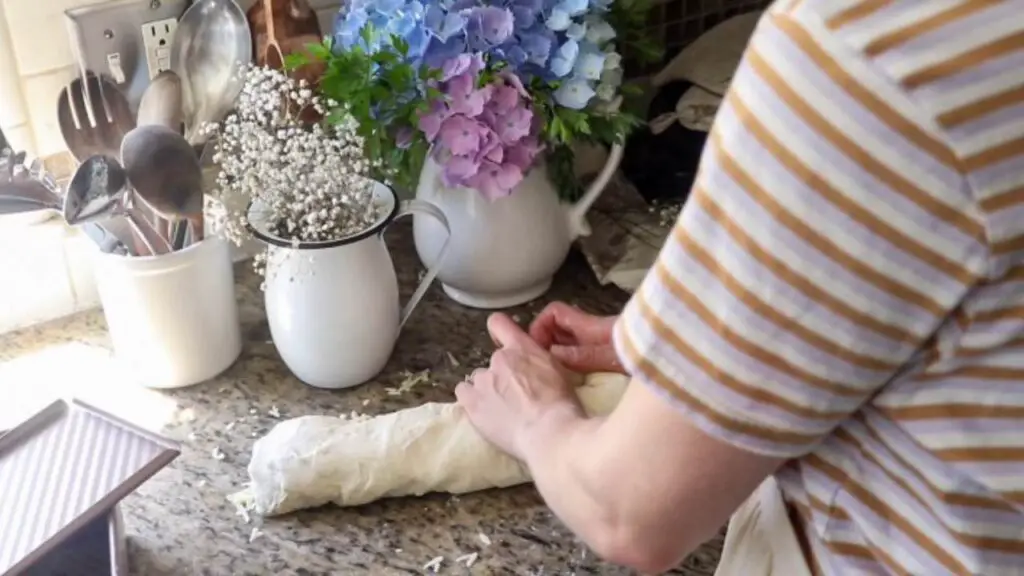 Shaping a loaf of cheese sourdough bread.