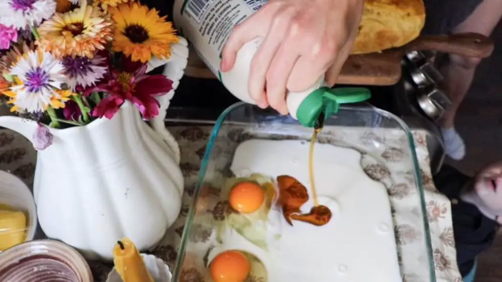 Pouring maple syrup into a casserole dish with eggs and milk.