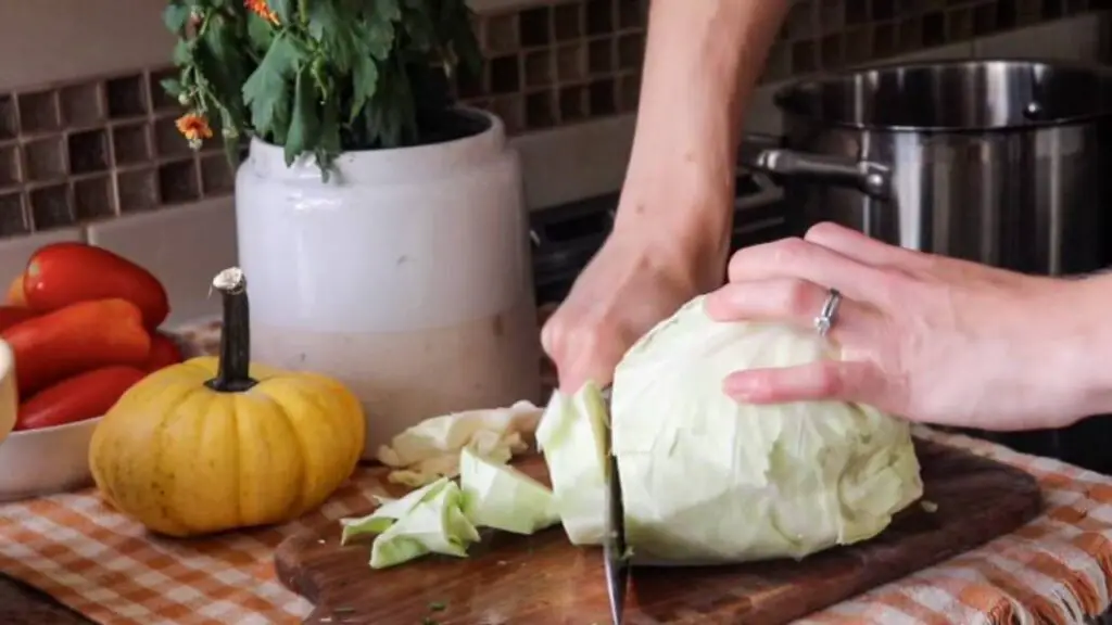 Chopping a cabbage on a wooden cutting board.