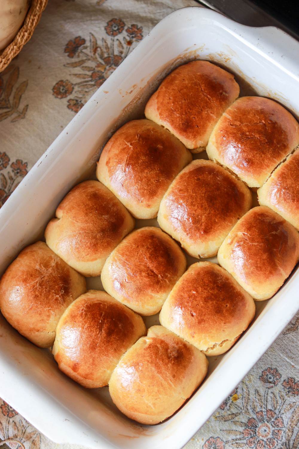 A white baking dish with freshly baked rolls in it.