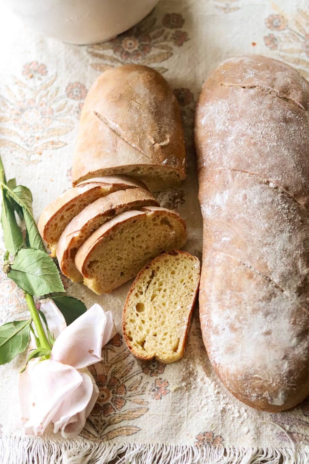 A loaf of sourdough einkorn french bread next to a sliced loaf.