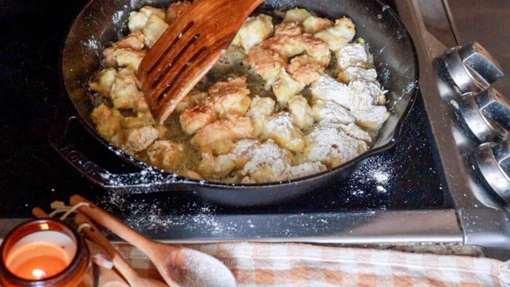 Frying breaded chicken cubes.