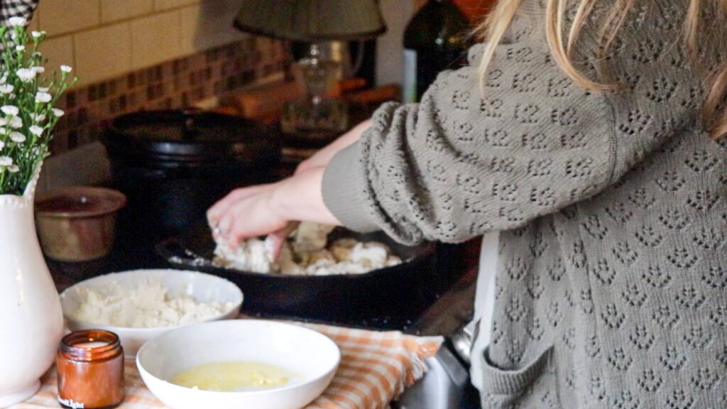 Adding breaded chicken to a pan.