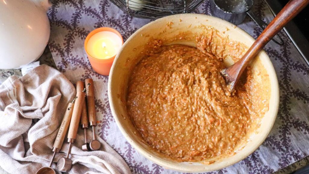 cupcake batter in a bowl with wooden spoon for homemade carrot cake cupcakes.