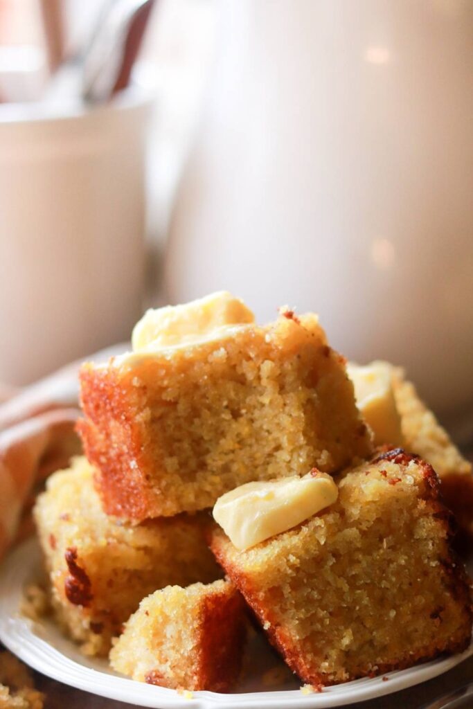 A plate of cornbread with butter.