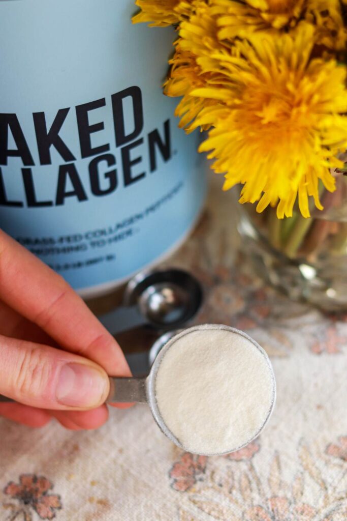 Holding a tablespoon of naked collagen peptide powder.
