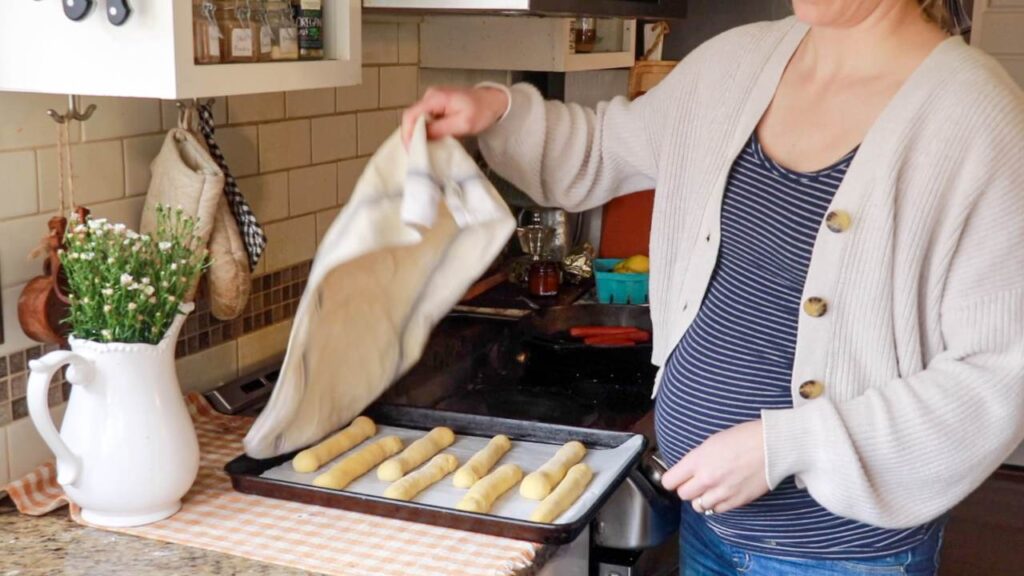 Covering a tray of hot dog buns with a towel.