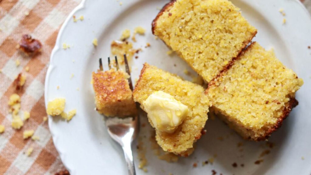 Three pieces of cornbread with butter and a fork.