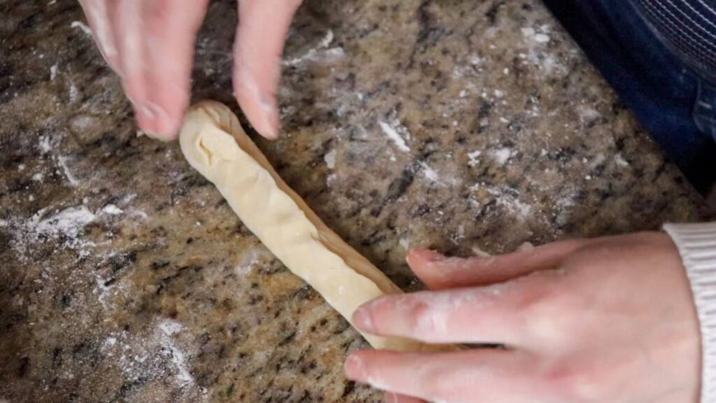 Pinching a hot dog bun closed.