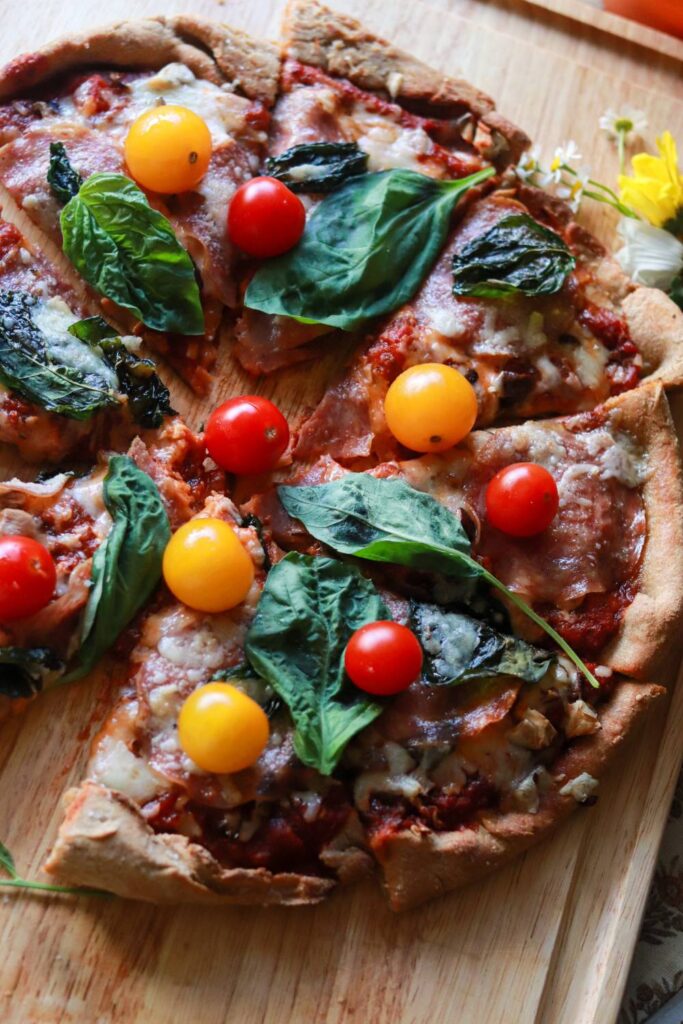 Rustic sourdough pizza with golden crust, vibrant cherry tomatoes, fresh basil, and melted cheese.