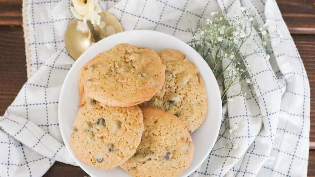 Plate of sourdough discard chocolate chip cookies on a white plate with decorative flowers around.