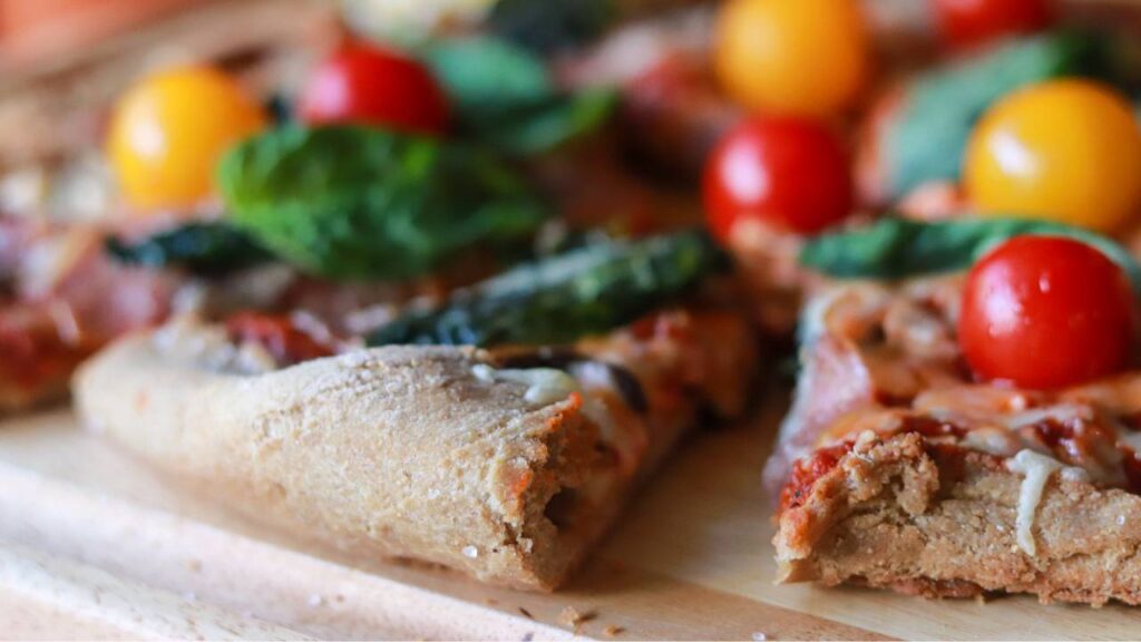 Close-up of thick, freshly milled pizza crust with a bite taken out.